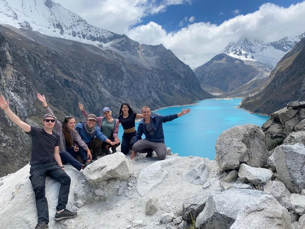 Viajeros frente a una laguna glaciar de la Cordillera Blanca